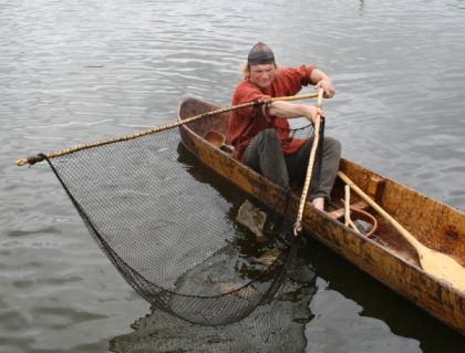 Ein Fischer im Boot mit Fischernetz