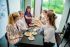 Eine Gruppe von Frauen sitzen um einen Gedeckten Tisch herum mit Kaffee und Kuchen.