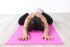 Eine Frau liegt in einer Yoga Pose auf einer Yoga Matte.