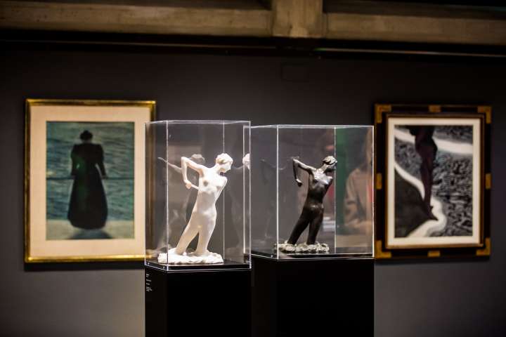 Blick in die Ausstellung mit zwei Skulpturen von Minne im Vordergrund und zwei Gemälden von Spilliaert im Hintergrund